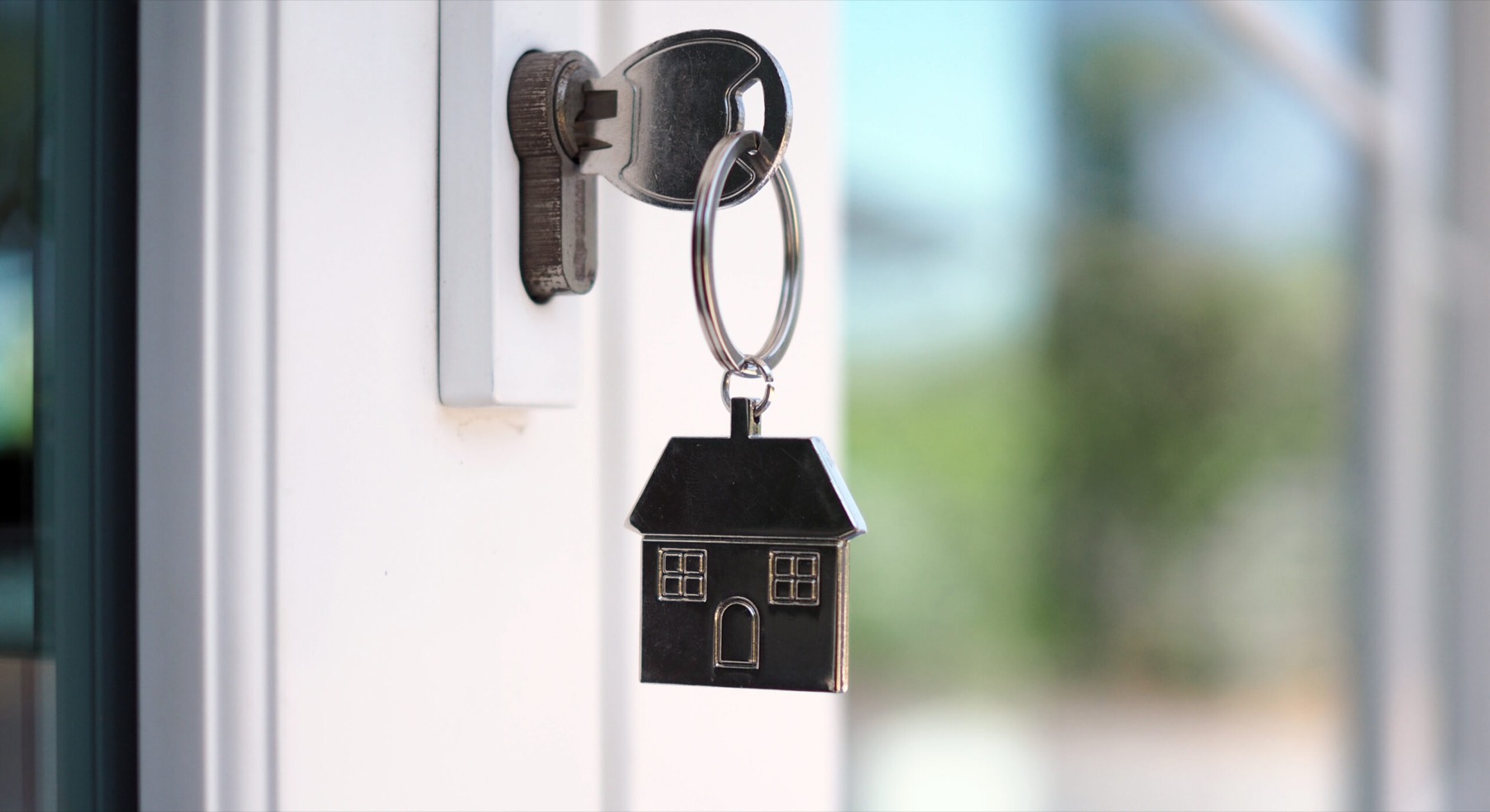 A key with a house keyring in a front door lock